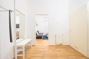 Una habitación con paredes blancas y suelo de madera. en Anna and Friends First floor, en Graz