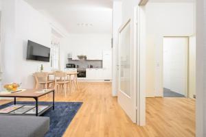 sala de estar blanca con mesa y cocina en Anna and Friends First floor, en Graz 24 fotos más