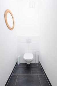 Un baño blanco con inodoro y espejo. en Anna and Friends First floor, en Graz