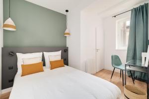 Un dormitorio con una gran cama blanca y un escritorio. en Le Coquet des Trois-Maisons avec parking privatif, en Nancy 6 fotos más