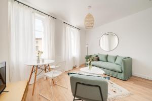 Una sala de estar con un sofá verde y una mesa. en Le Coquet des Trois-Maisons avec parking privatif, en Nancy