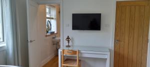 a room with a desk and a television on a wall at 21KR Bed and Breakfast, close to beach, town centre and golf in St. Andrews