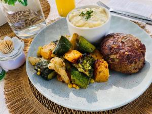 a plate of food with potatoes and vegetables on a table at Dips And T Hotel & Spa in Bloemfontein