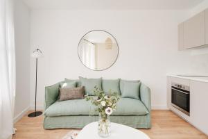 sala de estar con sofá verde y espejo en Le Coquet des Trois-Maisons avec parking privatif, en Nancy