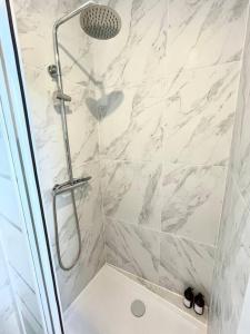 a bathroom with a shower with a glass door at Studio 10min Paris Centre I CDG in Drancy +14 photos