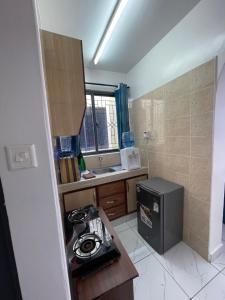 a small kitchen with a sink and a refrigerator at Comfortable Studio Apartment in Bamburi in Mombasa