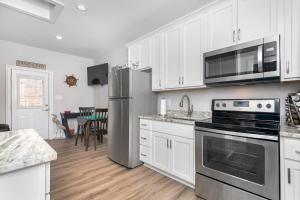 a kitchen with white cabinets and a stainless steel refrigerator at Tiny Luxury Studio GuestHouse in Deltaville in Deltaville +15 photos