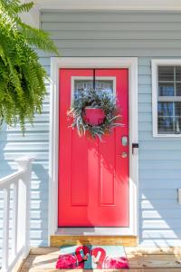 a red door on a house with a wreath at Tiny Luxury Studio GuestHouse in Deltaville in Deltaville