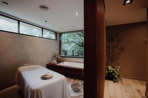 a bathroom with a bath tub and a table with a plate on it at La Urumpta Hotel, AKEN MIND in Río Cuarto