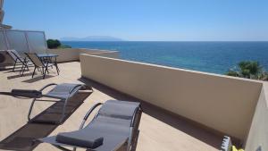 a balcony with chairs and a table and the ocean at Ionian Moon 2 in Preveza