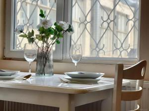 einen Tisch mit zwei Gläsern und eine Vase mit weißen Blumen in der Unterkunft City center Apartment 14 in Baku