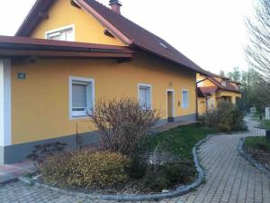 a yellow house with a walkway in front of it at dieUnterkunft in Neutillmitsch