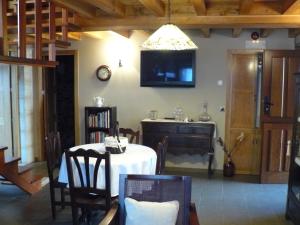 a dining room with a table and a tv at Casa Rural Dona María in Ordes