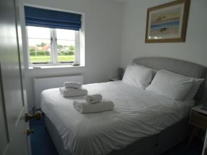 a bedroom with a bed with two towels on it at 3 double bed house with parking in Sheringham in Sheringham