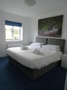 a bedroom with a large bed with white sheets at 3 double bed house with parking in Sheringham in Sheringham
