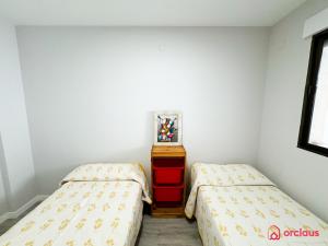 une chambre avec deux lits et une commode dans l'établissement El Suspiro, à Oropesa del Mar