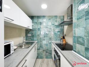 une cuisine avec des placards blancs et du carrelage vert dans l'établissement El Suspiro, à Oropesa del Mar