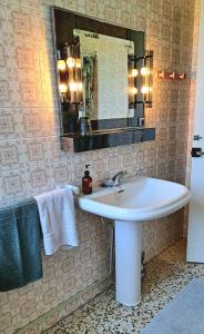 a bathroom with a sink and a mirror and towels at Casa Natura Galicia in Santa María La Mayor del Rosario