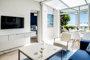 a living room with a tv and a couch and a table at Sea Escape in Cape Town