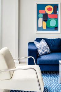 a blue couch and a white chair in a living room at Sea Escape in Cape Town
