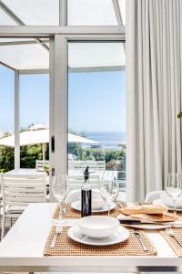 a white table with glasses and a plate on it at Sea Escape in Cape Town