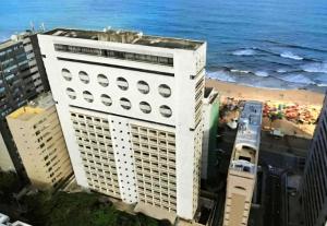 a tall white building next to the beach at Mercure Recife Navegantes - Privado in Recife