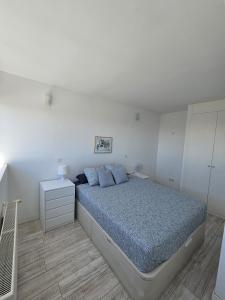 ein weißes Schlafzimmer mit einem Bett und einem weißen Schrank in der Unterkunft Cómodo apartamento en Madrid in Madrid