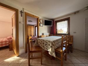 un comedor con mesa y sillas y una habitación en Livigno Elisir Petit, en Livigno