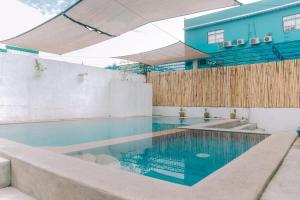 a swimming pool in front of a blue building at Hera Maria Hotspring Resort in Calamba +19 photos