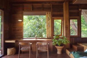 a room with two chairs and a window in a cabin at ทโล้ โฮมสเตย์ เชียงใหม่ | Taloh Homestay Chiangmai in Mae On