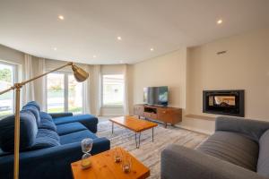 un soggiorno con divani blu e TV di GuestReady - Sunshine oasis with pool ad Azeitao