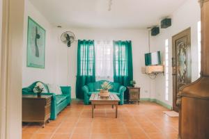 a living room with green furniture and a table at Hera Maria Hotspring Resort in Calamba