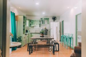 a kitchen with green cabinets and a table and chairs at Hera Maria Hotspring Resort in Calamba