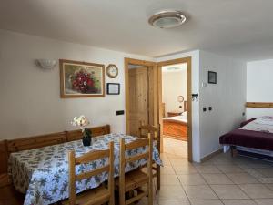 Un comedor con una mesa y un dormitorio. en Livigno Elisir Petit, en Livigno