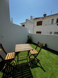 Una mesa de madera y dos sillas en un patio. en Ocean Apartment, en Carvoeiro