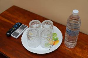 un piatto di bicchieri e una bottiglia d'acqua su un tavolo di Le Springlynn Residency a Pondicherry
