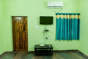 Camera con porta, TV e tavolo di Le Springlynn Residency a Pondicherry