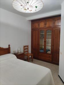 Un dormitorio con una cama y una lámpara de araña. en Comparte Espacio en Chiclana, en Chiclana de la Frontera