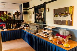 un ristorante con un bancone con del cibo sopra di Hotel Orion a Kaag Altre 23 foto