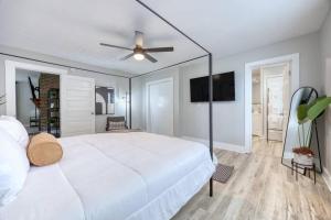 a bedroom with a large white bed with a ceiling fan at Downtown Family Retreat,15 mins to Fort Benning in Columbus