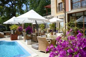a patio with a pool and chairs and umbrellas at Harmony Suites Jungle - Apartment Veron in Sunny Beach