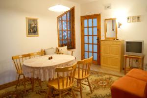 a dining room with a table and chairs and a television at Guest House Barbov in Obzor