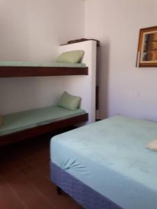a room with a bed and shelves in a room at Confortável Casa na Praia do Indaiá Bertioga in Bertioga