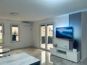 a living room with a flat screen tv on a wall at Apartman Zen in Bihać