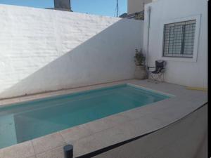 a swimming pool sitting next to a white wall at Casa Venicio 1 in Ciudad Lujan de Cuyo