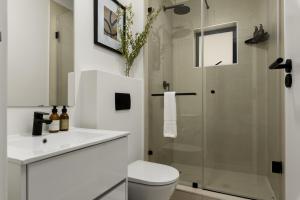 Un baño blanco con inodoro y ducha. en The Sage Luxury Apartment Hotel, en Ciudad del Cabo 141 fotos más