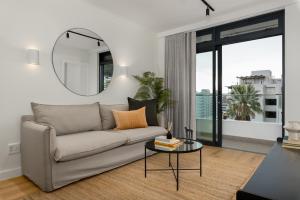 Una sala de estar con un sofá y un espejo. en The Sage Luxury Apartment Hotel, en Ciudad del Cabo