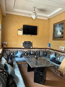 a living room with a couch and a tv at Ouzoud le Panorama in Ouzoud