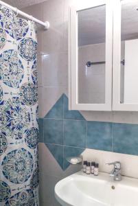 a bathroom with a sink and a shower curtain at Grandma's Pine Apartments in Skála +27 photos