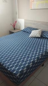 a blue comforter on a bed in a bedroom at Riviera Apto 443 in Caldas Novas